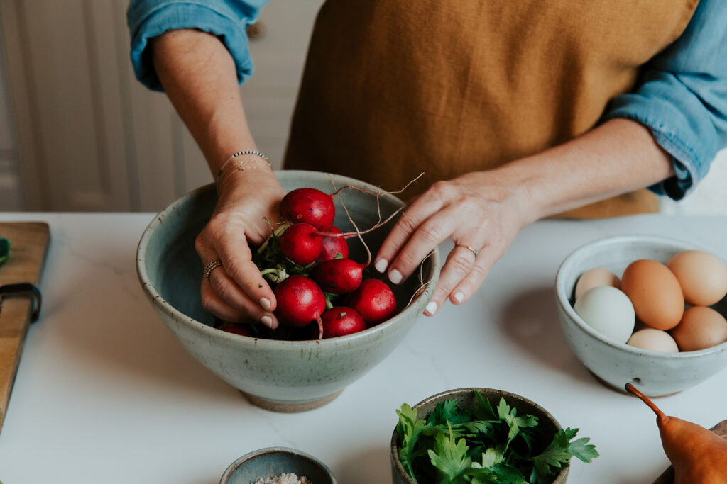 Client prepping food during her personal branding photoshoot in Hudson Valley, photographed by Julieanne Browning of Pine & Fable Photography.